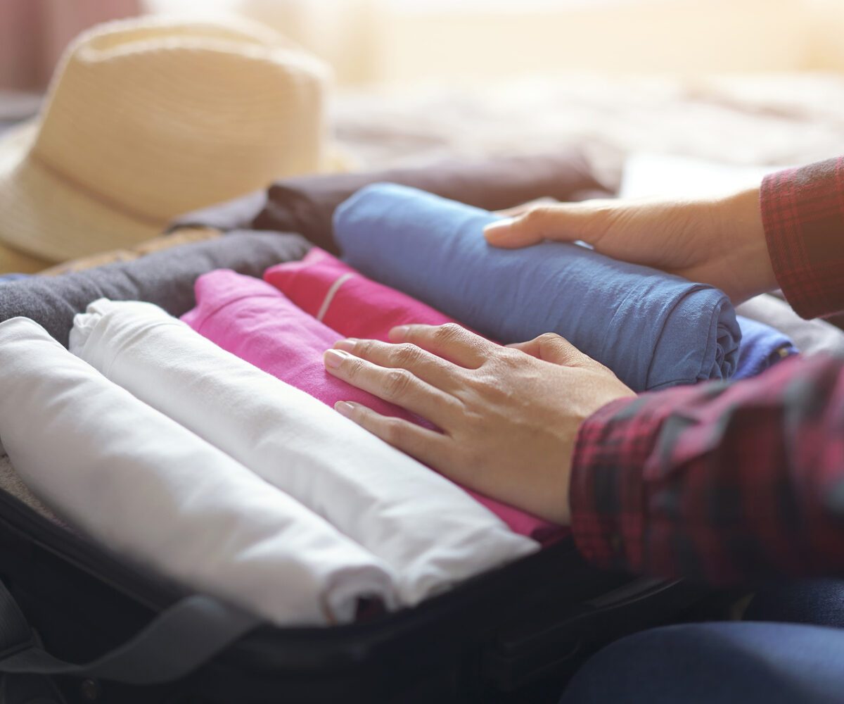 Woman packing clothes into a suitcase.