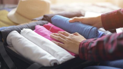 Woman packing clothes into a suitcase.