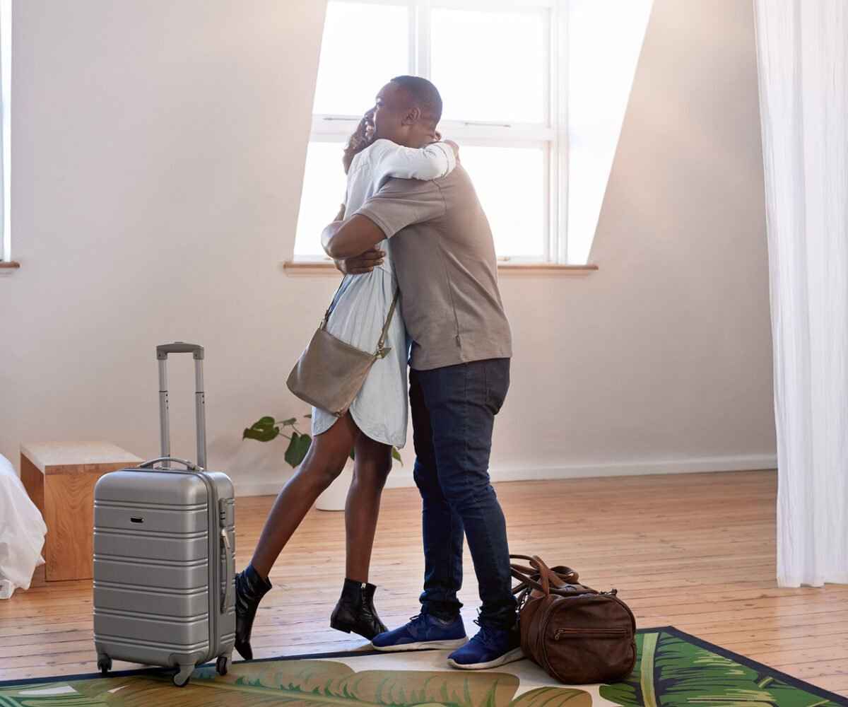 A young couple hugging in a vacation rental.