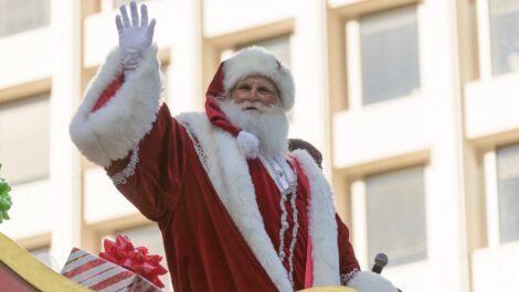 Santa waving at a Thanksgiving parade.