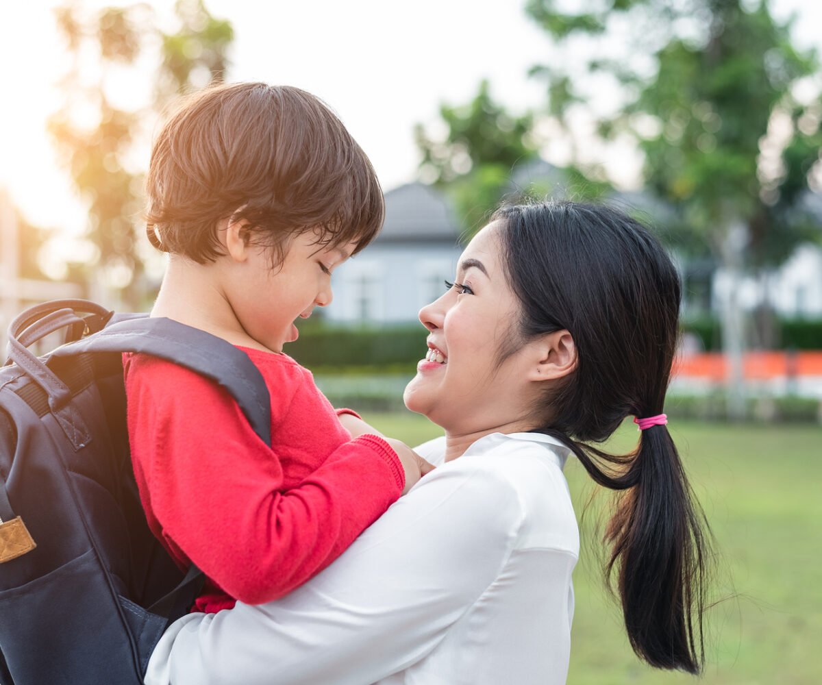 A mom hugging her toddler before school.