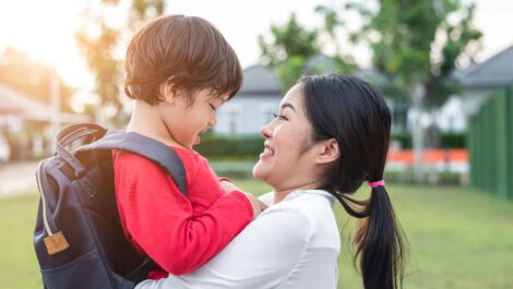 A mom hugging her toddler before school.