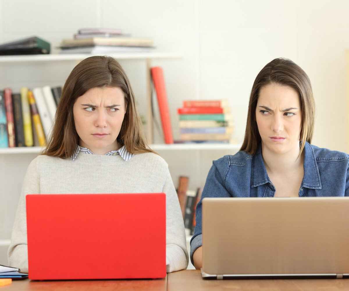 Two female college roommates glaring at each other.