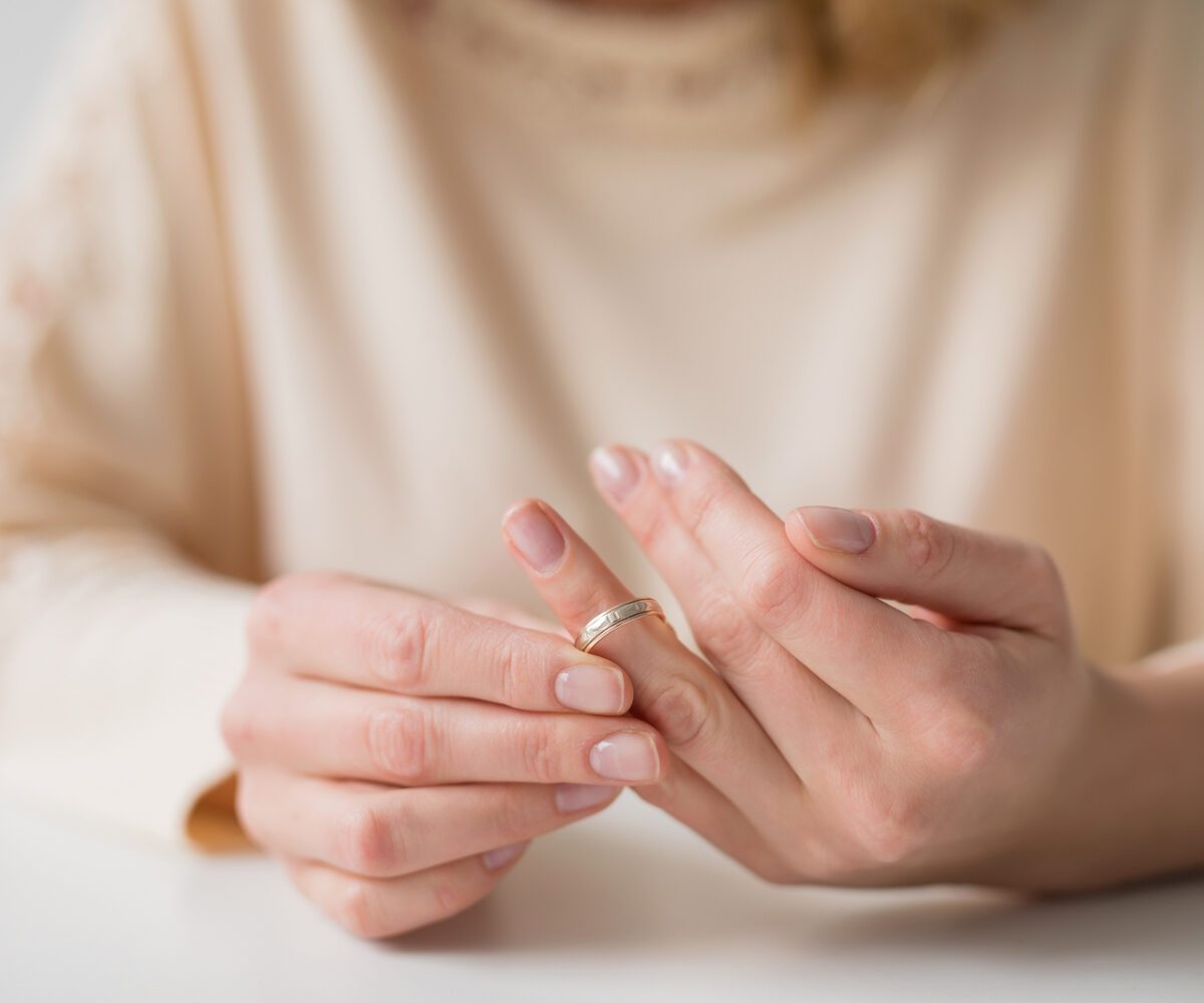 A woman taking off her wedding ring.