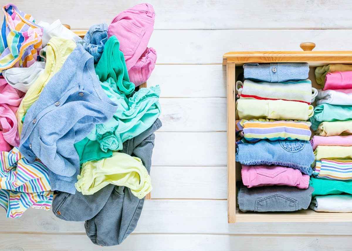 A messy pile of clothes next to clothes neatly folded in a drawer.