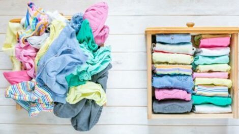 A messy pile of clothes next to clothes neatly folded in a drawer.