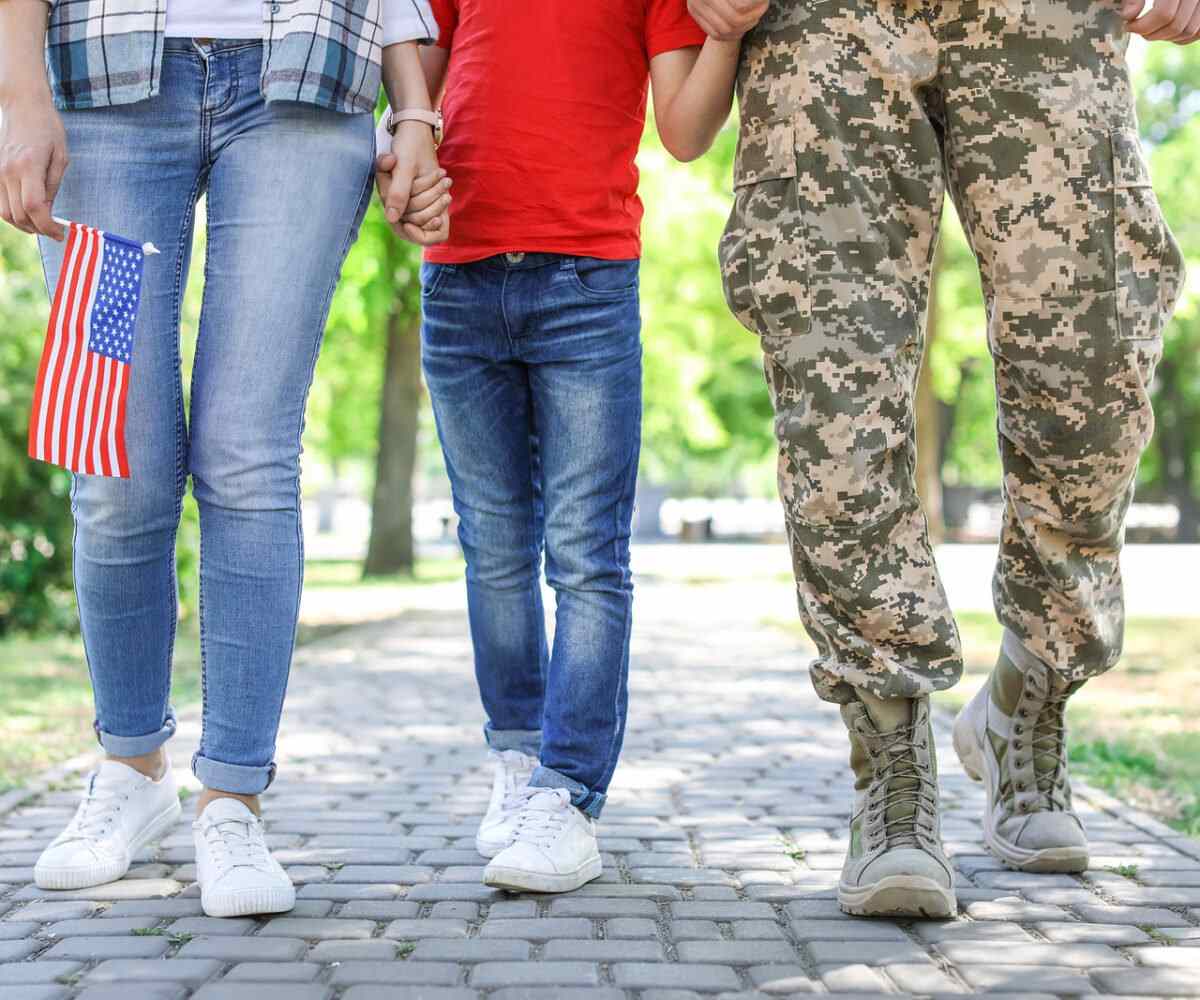 A military family holding hands.