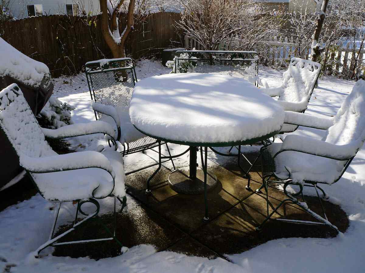 Outdoor patio furniture covered in snow.