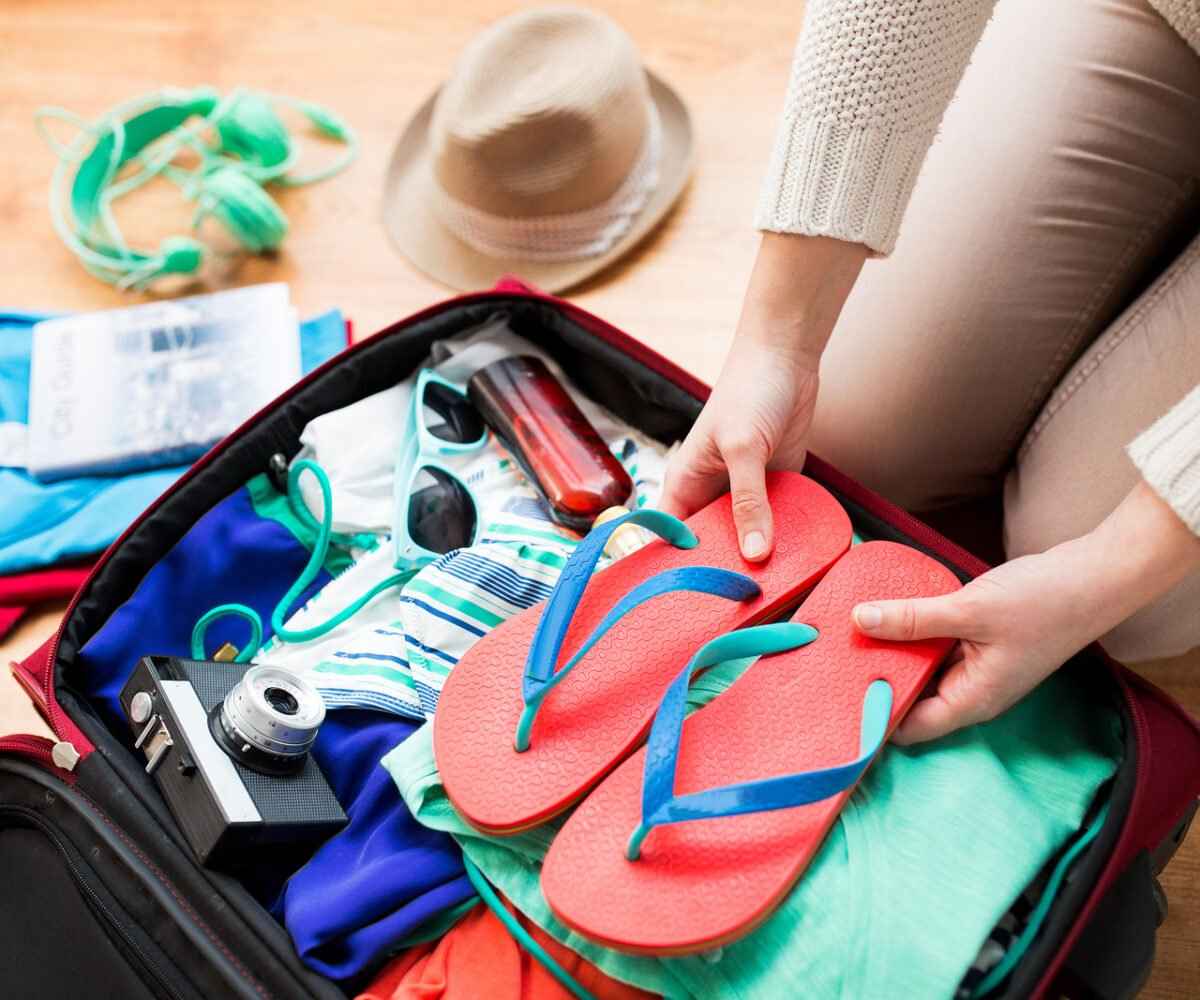 Woman packing a suitcase for a beach vacation.