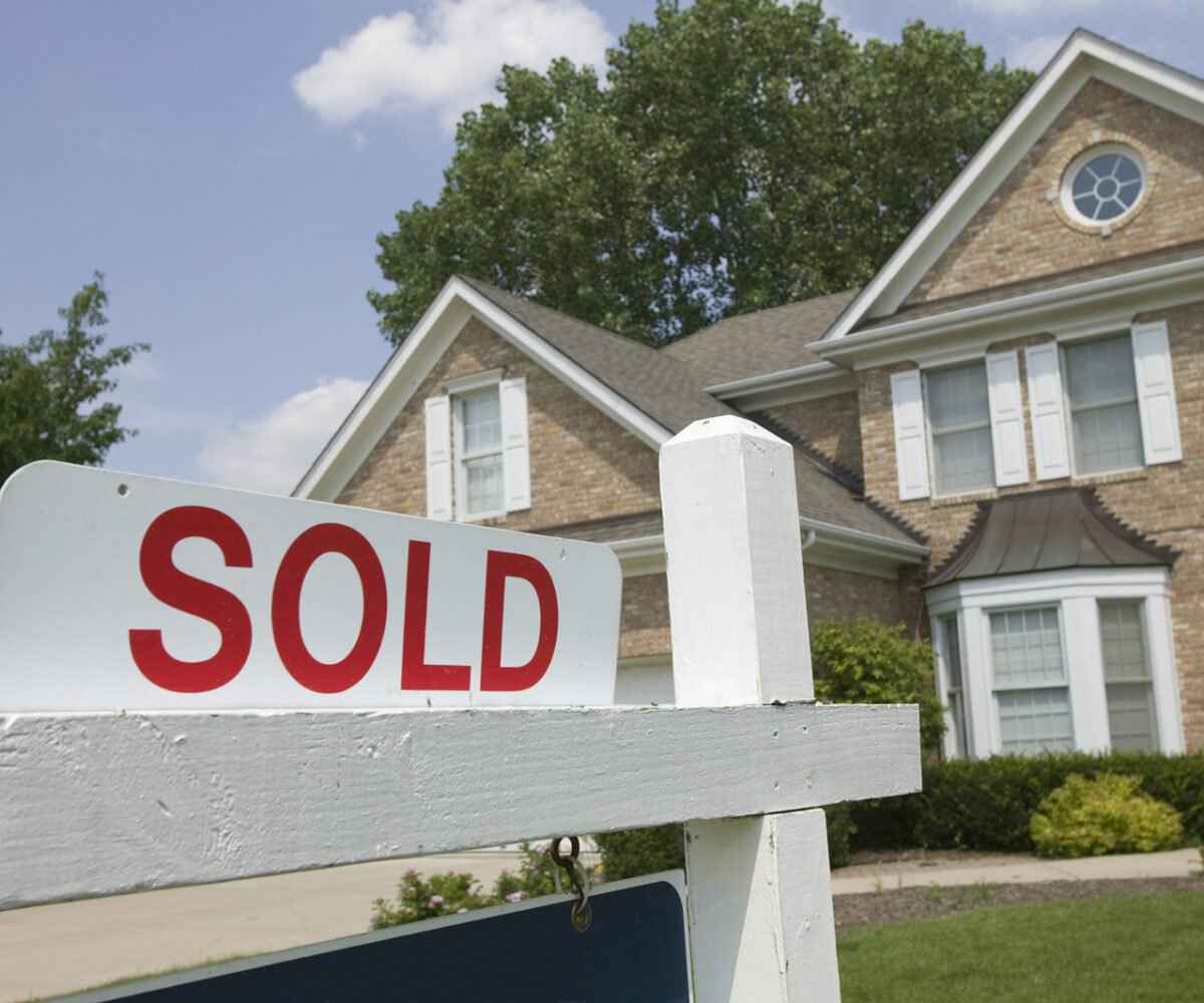 House with a sold sign in the front yard.