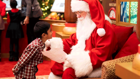 Little boy giving wish list to Santa.