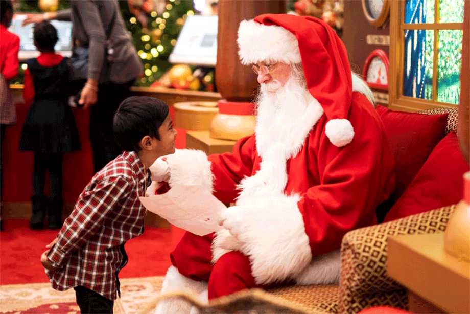 Little boy giving wish list to Santa.