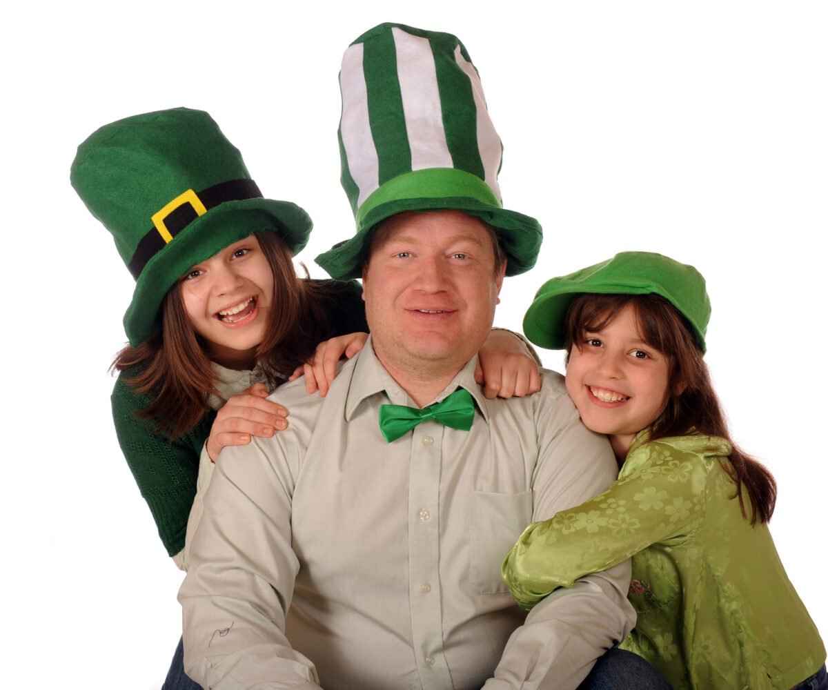 A man and two children wearing St. Patrick's Day accessories.