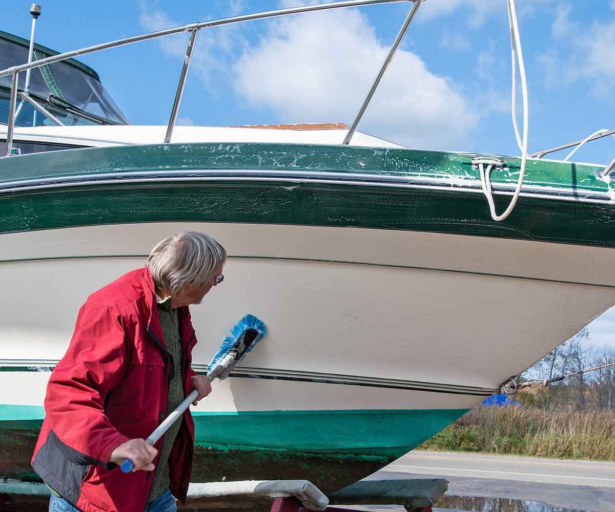A man cleaning the outside of a boat.
