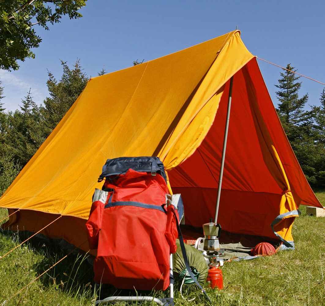 A tent and camping equipment in the forest.