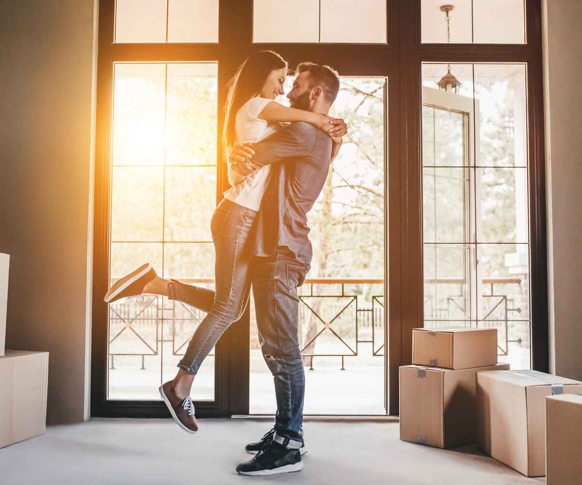 Man hugging a woman in a new home.