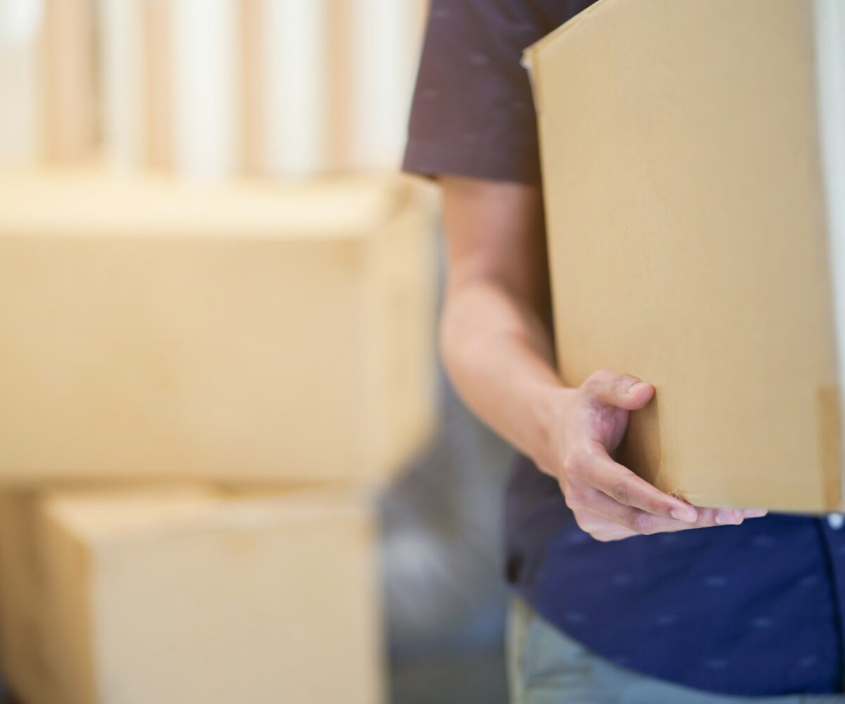 Person carrying a moving box.