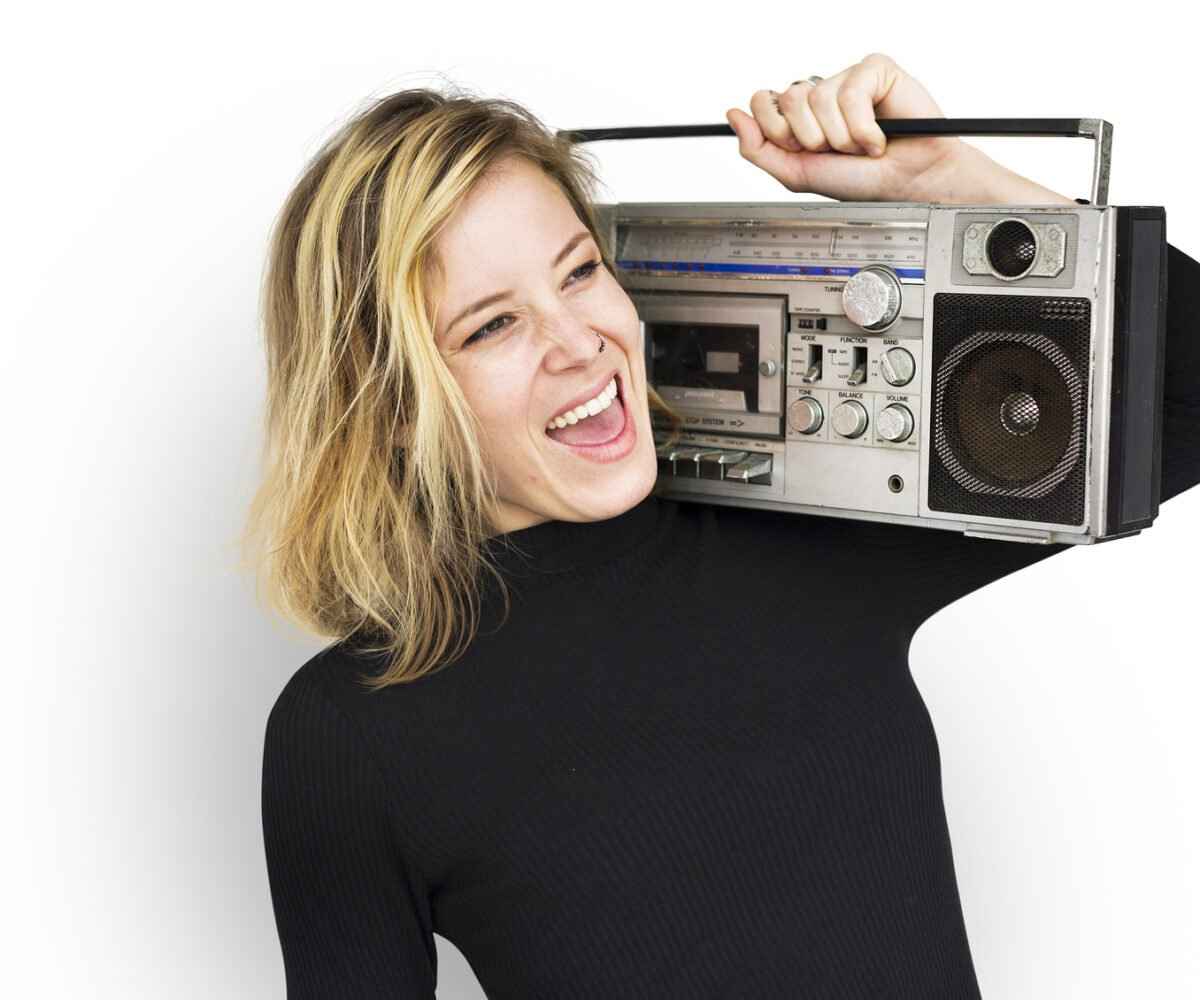 Young woman holding up a jukebox on her shoulder.