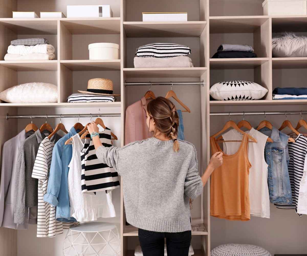 Woman looking at clothes in a closet.