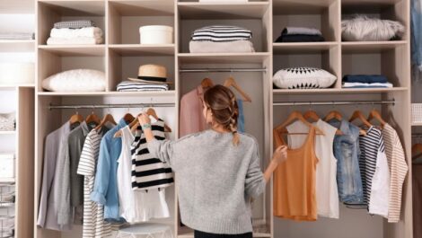 Woman looking at clothes in a closet.