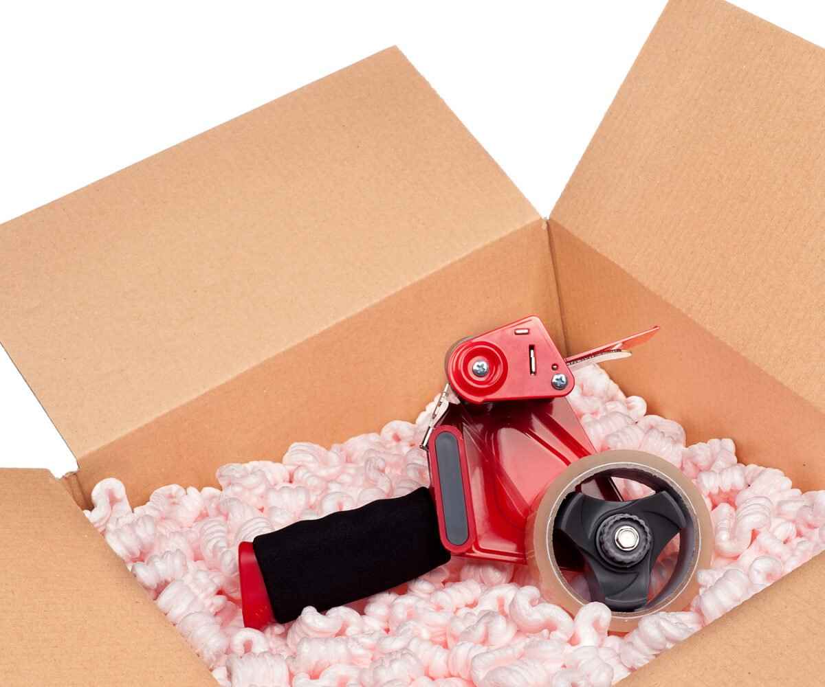 A box full of protective packaging peanuts and a tape dispenser.