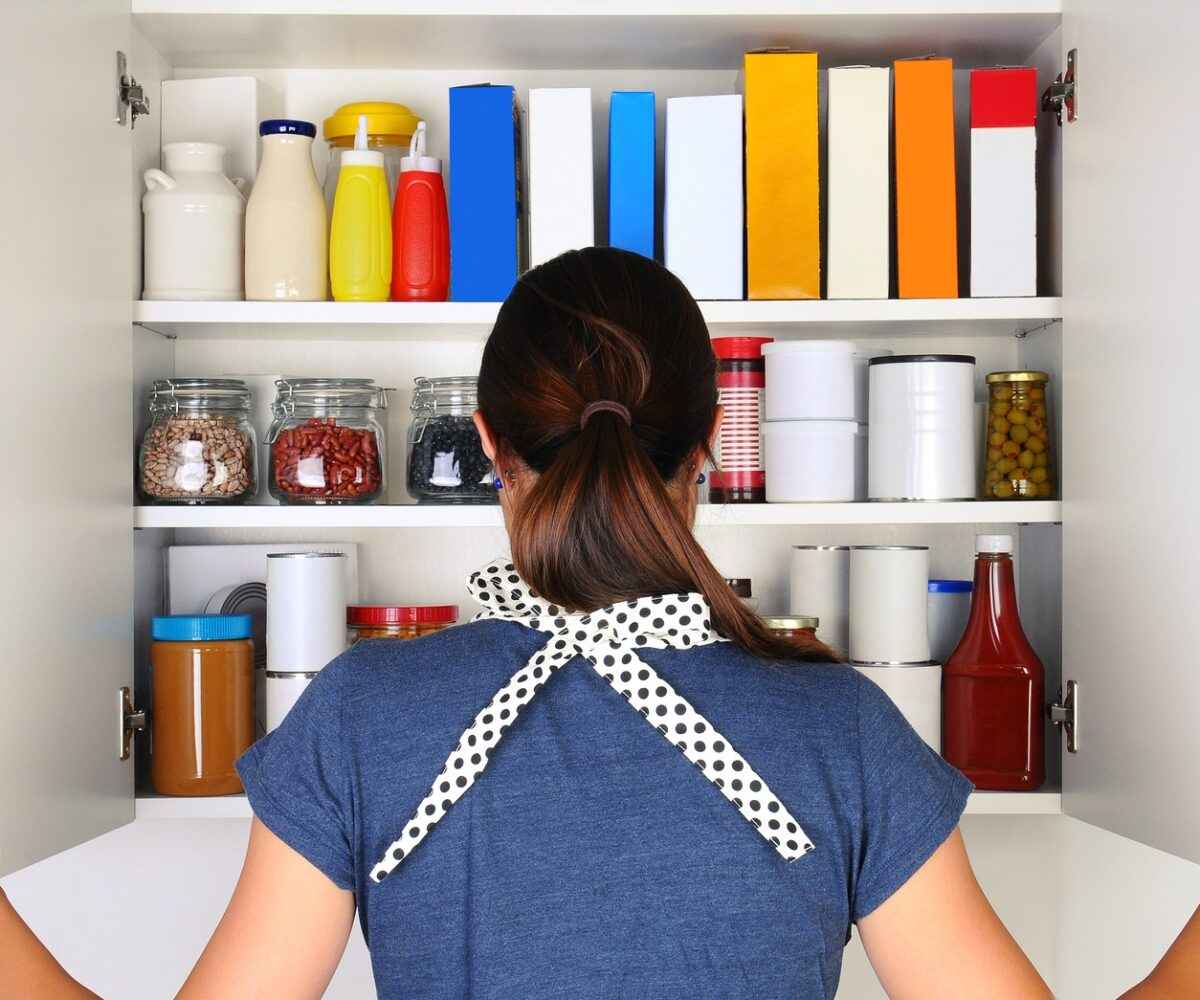 A woman looking into an organized pantry.