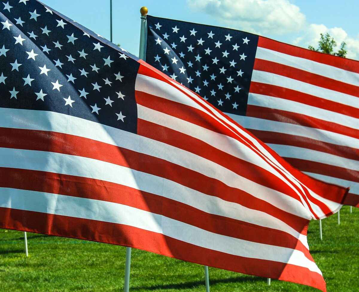 Two American flags waving in the wind.