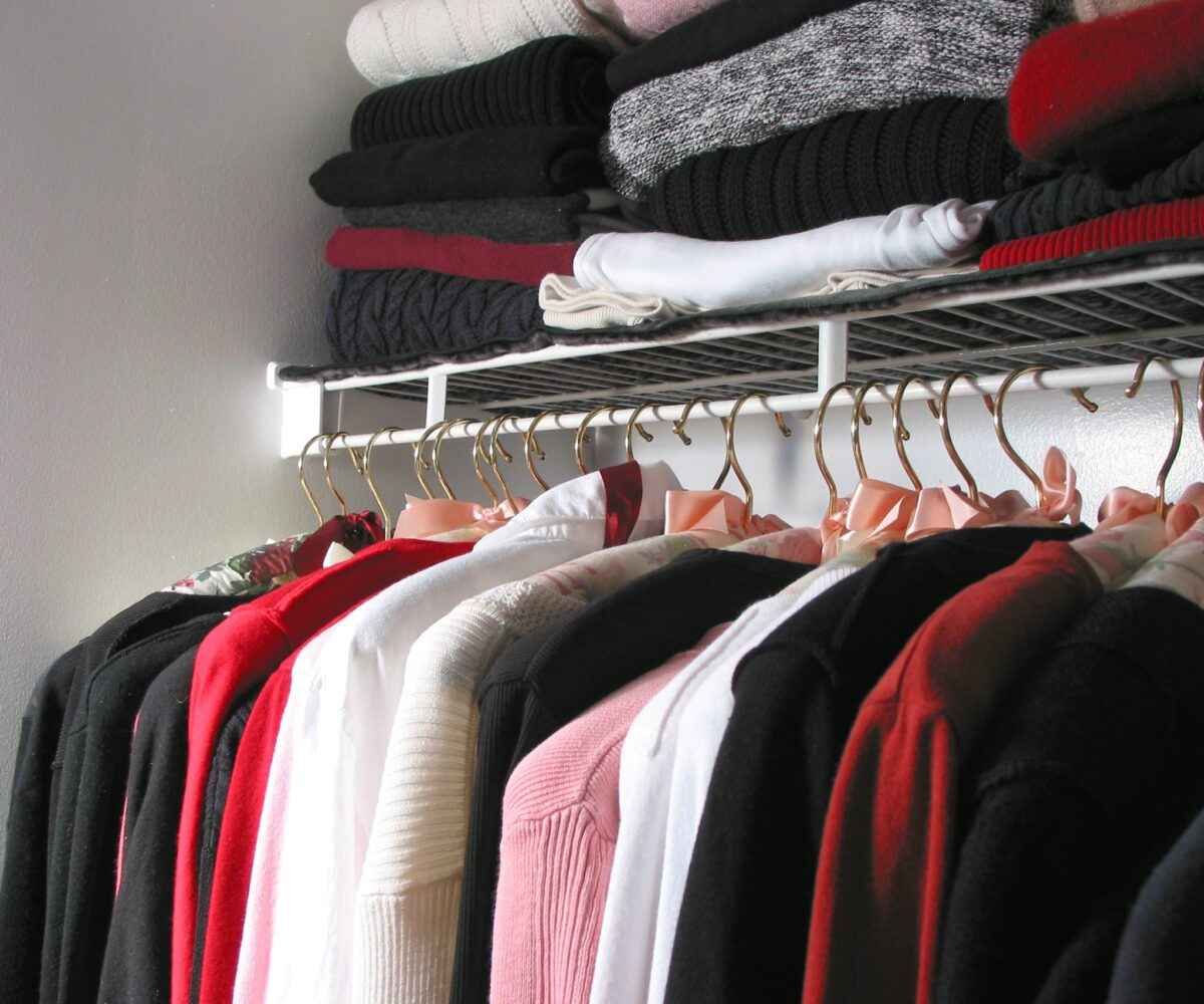 An organized closet filled with clothes.