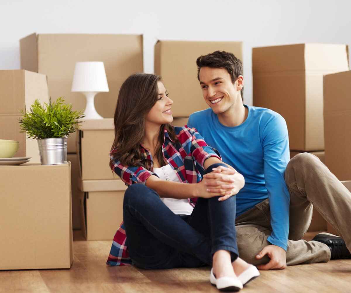 Young couple smiling in their new house.