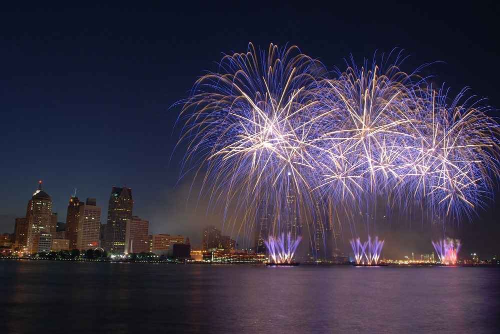 Fourth of July fireworks next to city.