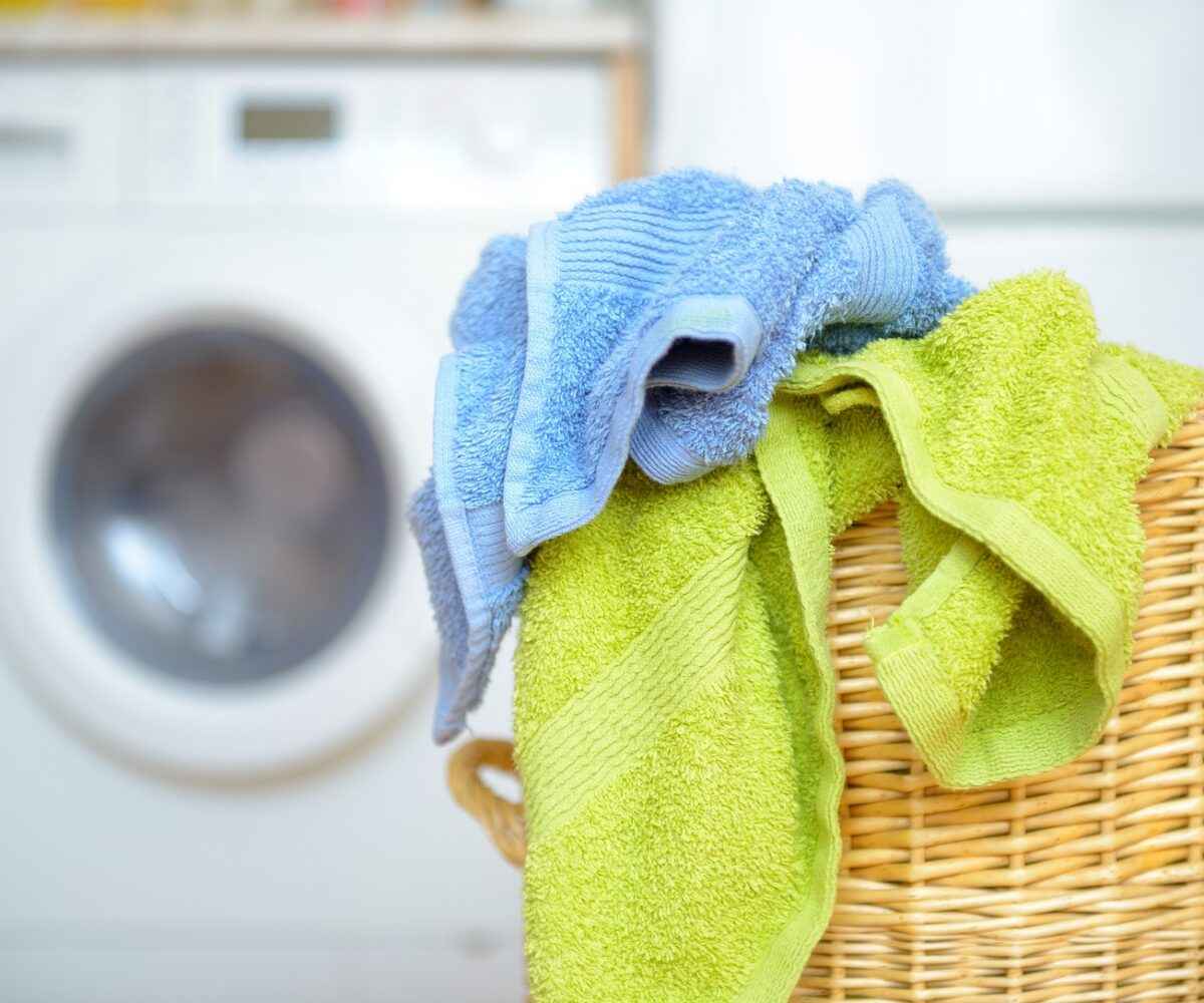 Two towels hanging out of a laundry basket.