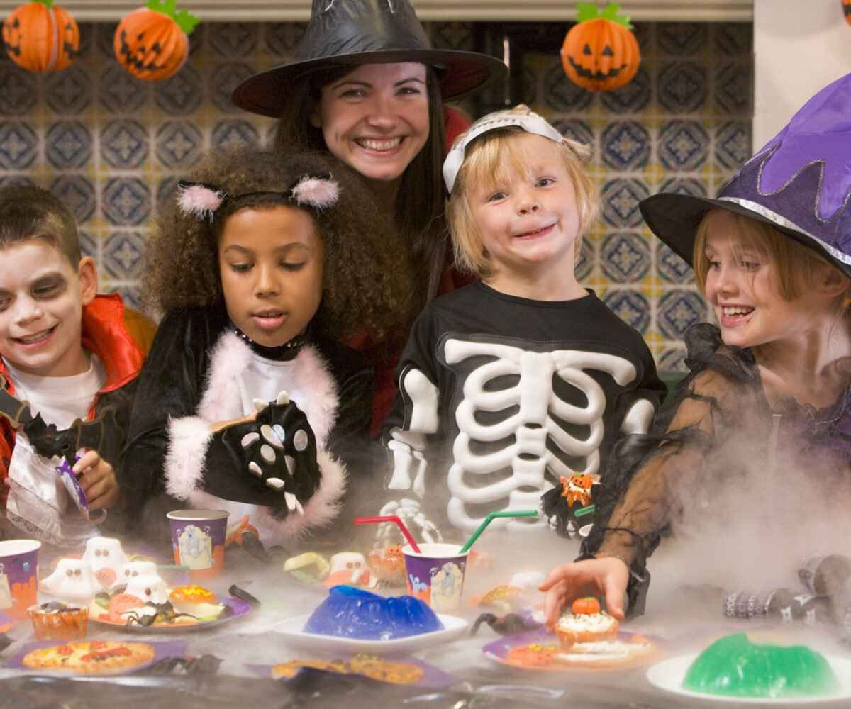 Four children and one adult celebrating Halloween.