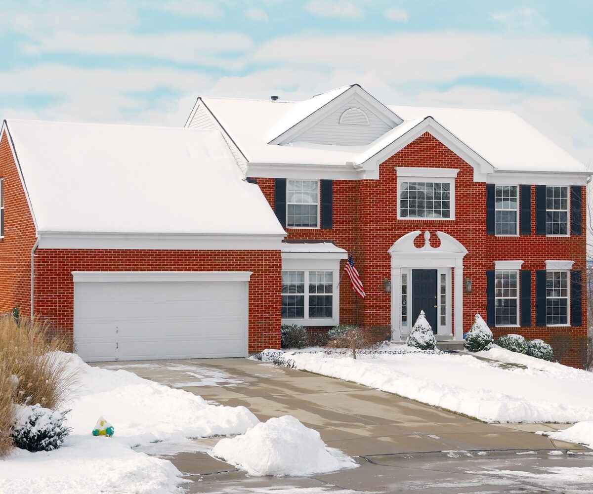 Red brick house covered in snow.