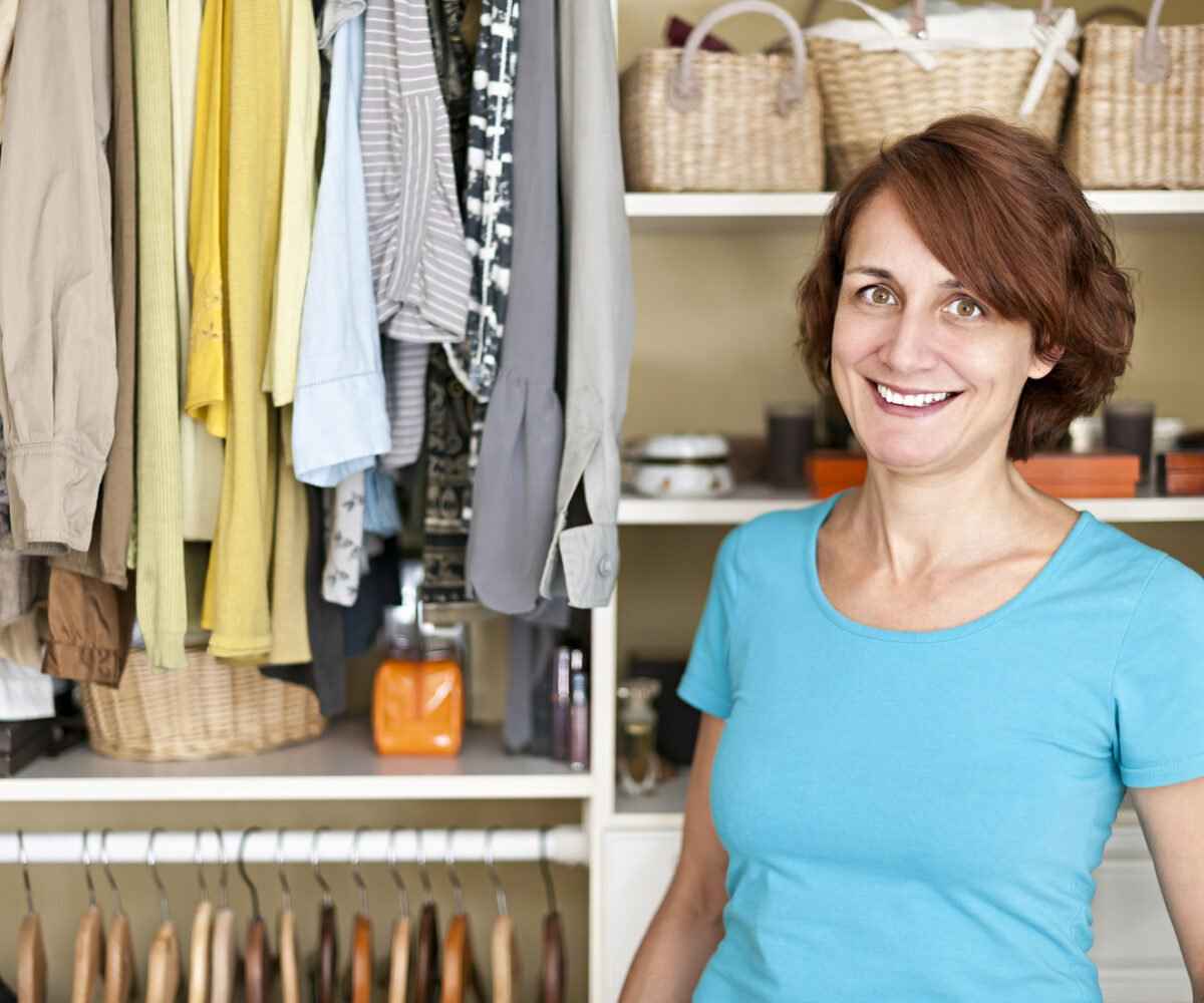 Woman smiling inside a closet.