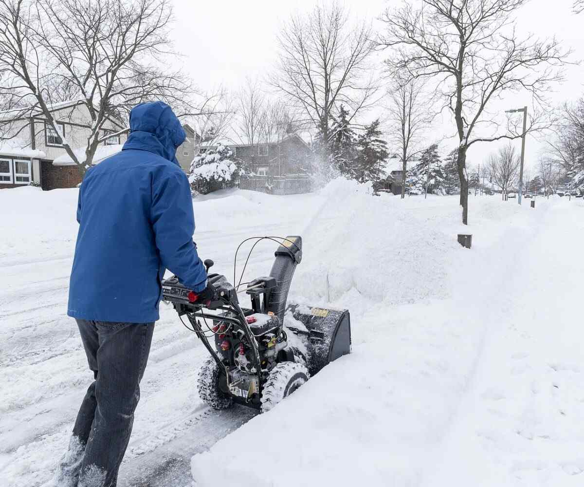 Man clearing snow with a snow blower.