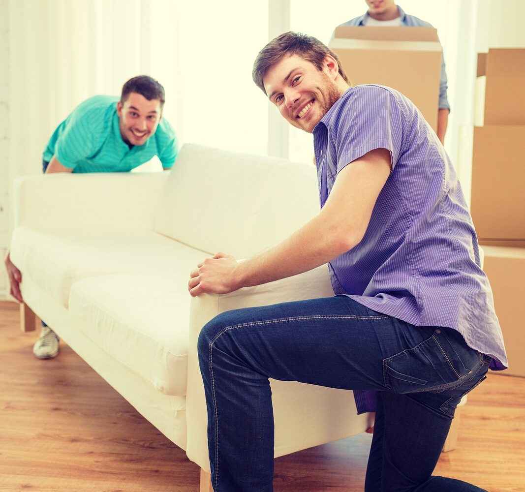 Two college students moving a couch.