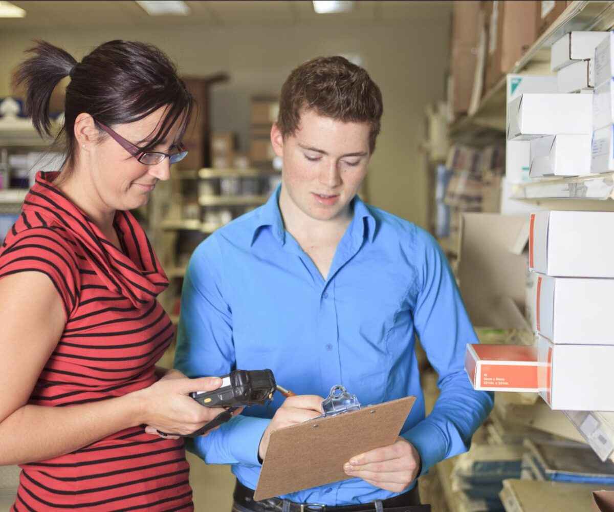 Two people counting inventory in a store's backroom.