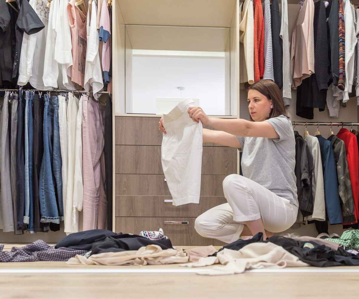 A woman organizing and decluttering her closet.