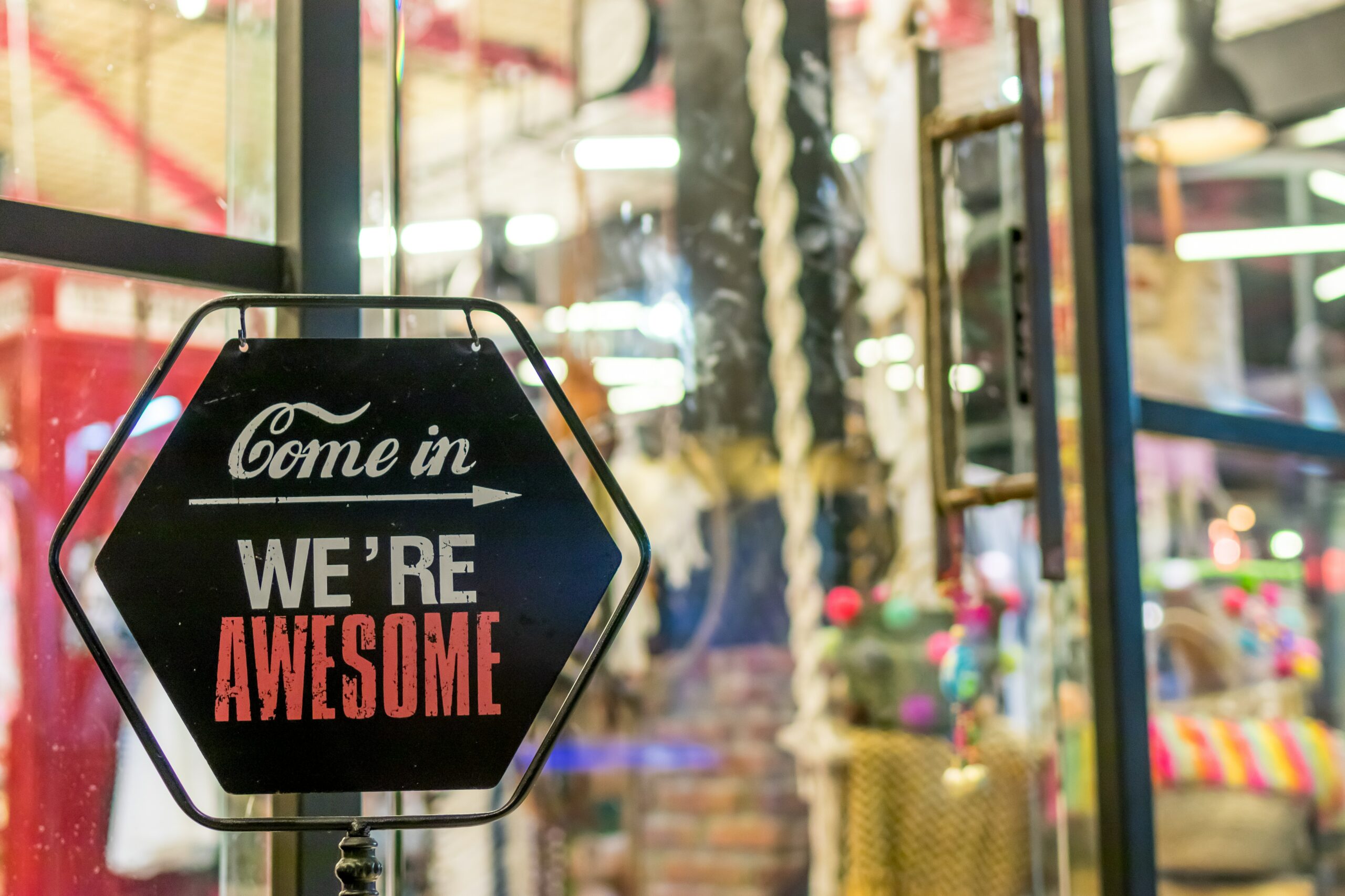 Store sign says "Come In, We're Awesome"