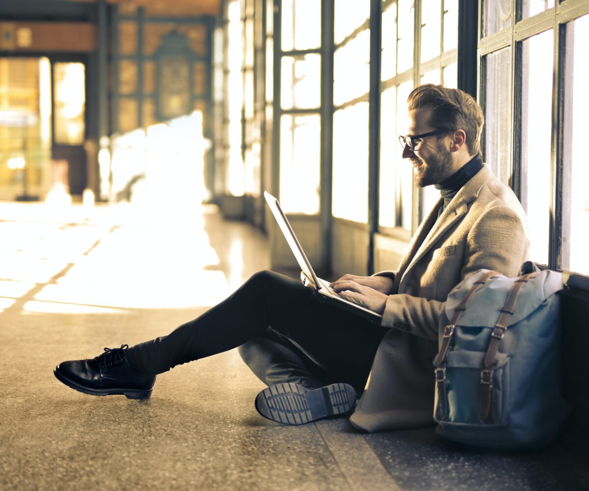 Man sitting on the floor on his laptop.