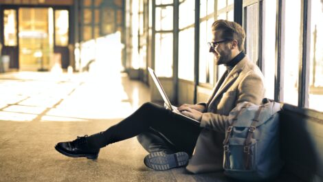 Man sitting on the floor on his laptop.