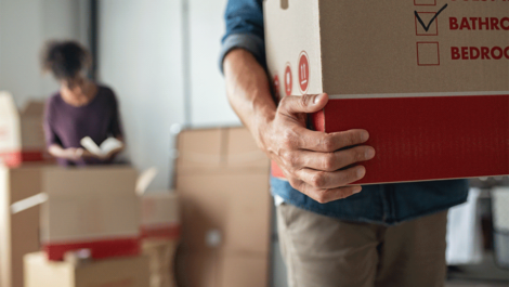 Man holding a cardboard moving box.