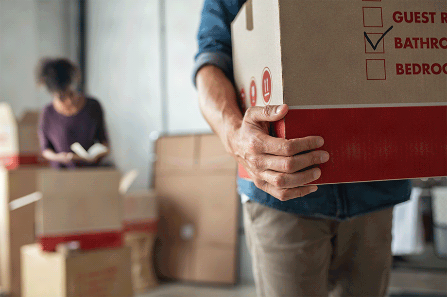 Man holding a cardboard moving box.