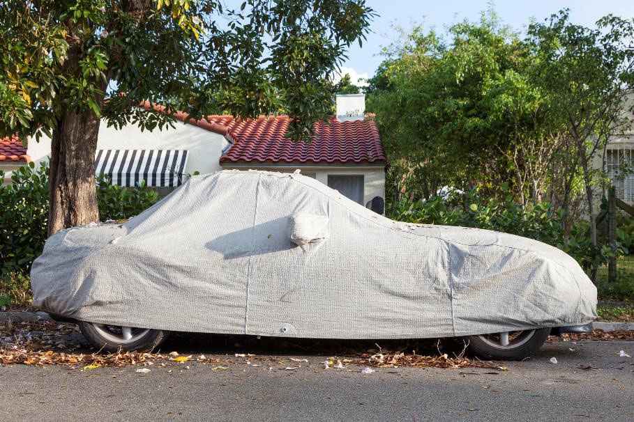 A car being stored in a car cover.