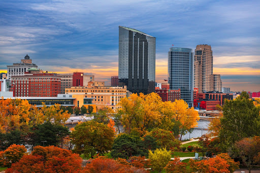 The Grand Rapids, MI, skyline in the fall, dotted with trees that have green, orange, and red leaves.