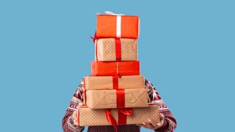 A man holding a stack of gifts.
