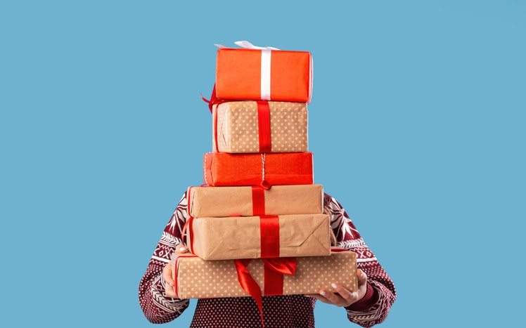 A man holding a stack of gifts.