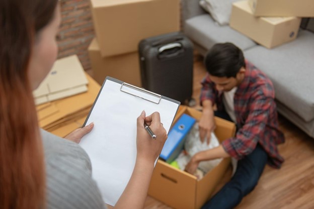 A couple packing boxes with a moving list.