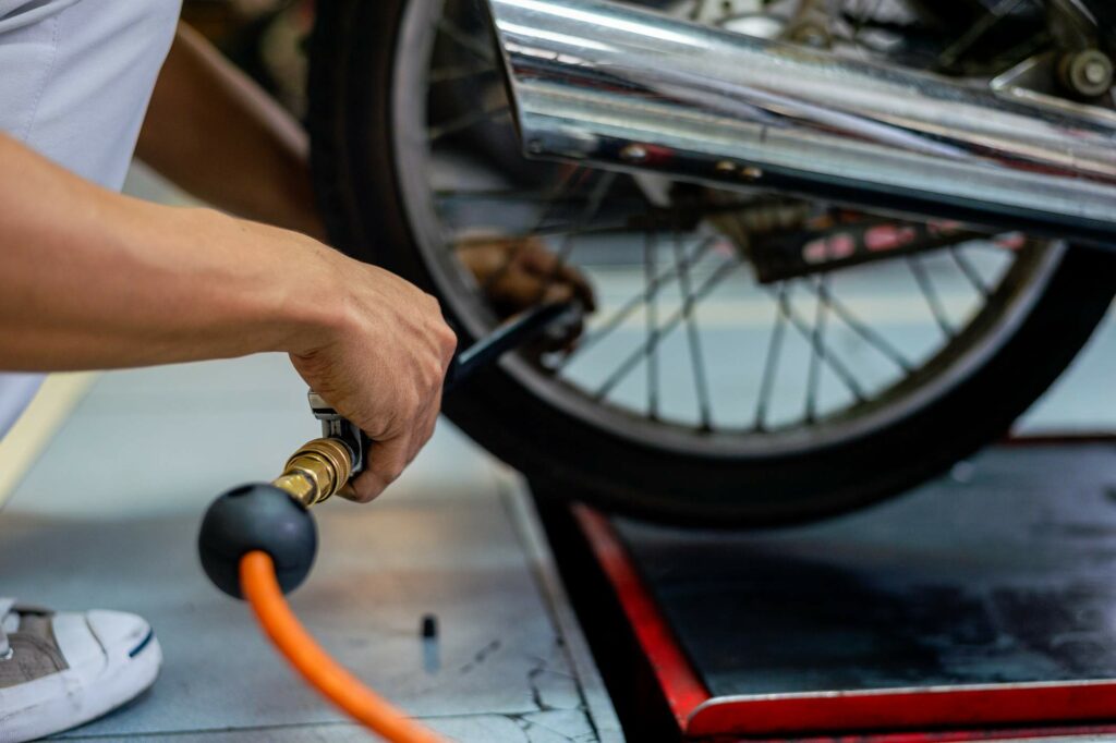 A motorcycle tire gets filled with air by an air compressor machine